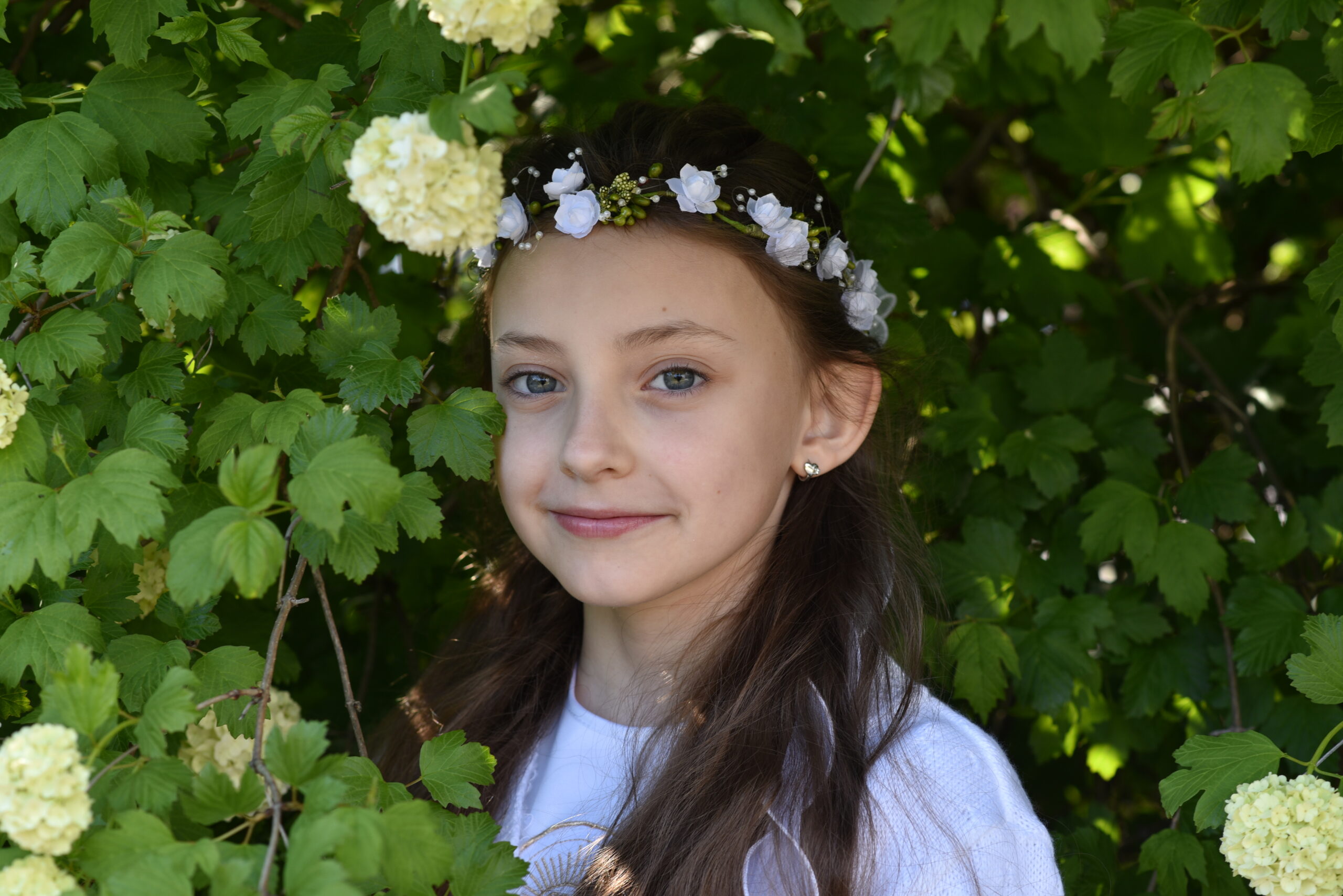 Komunijny portret wśród kwitnącej zieleni