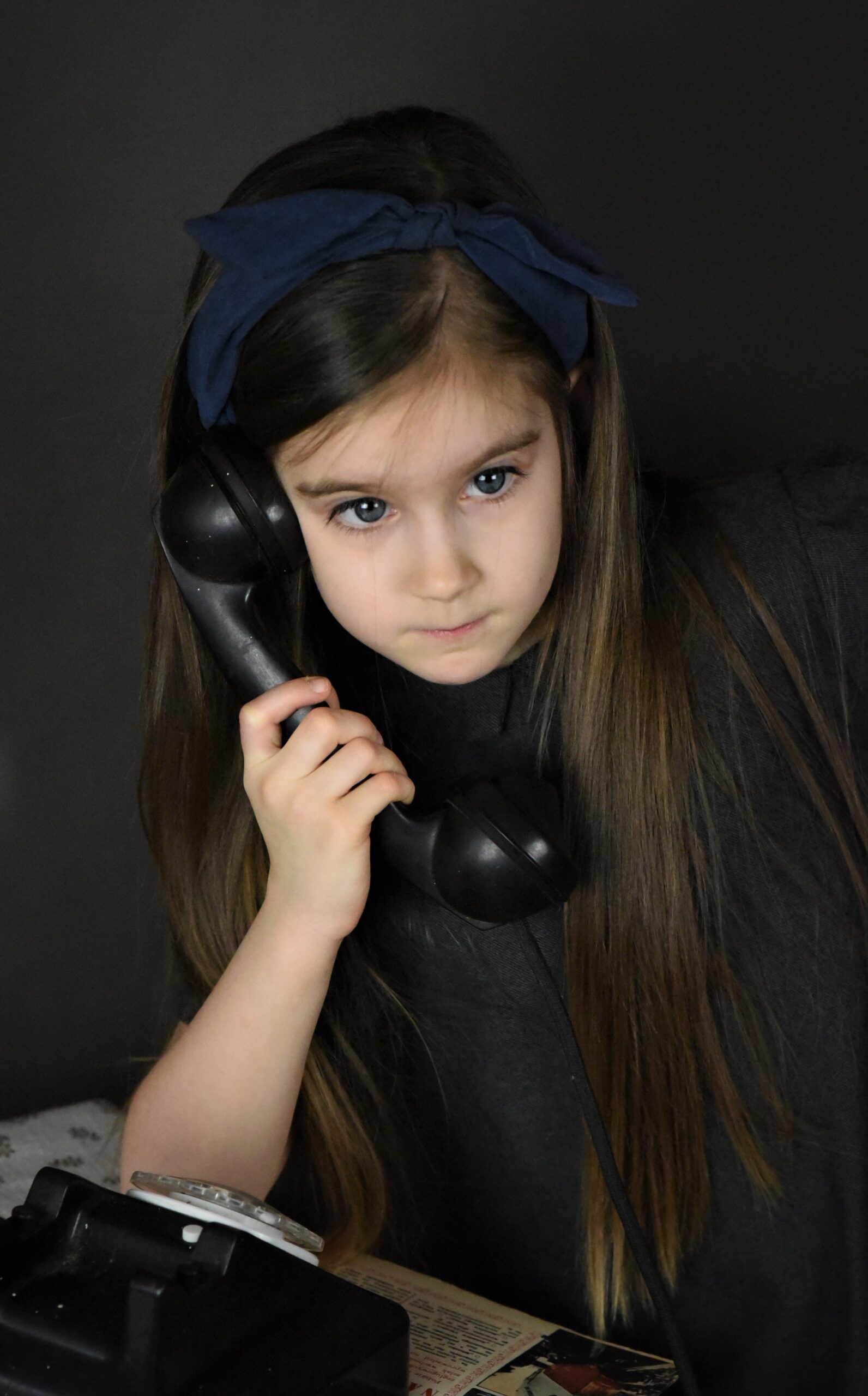 Poziomo kadrowany portret dziewczynki z telefonem retro