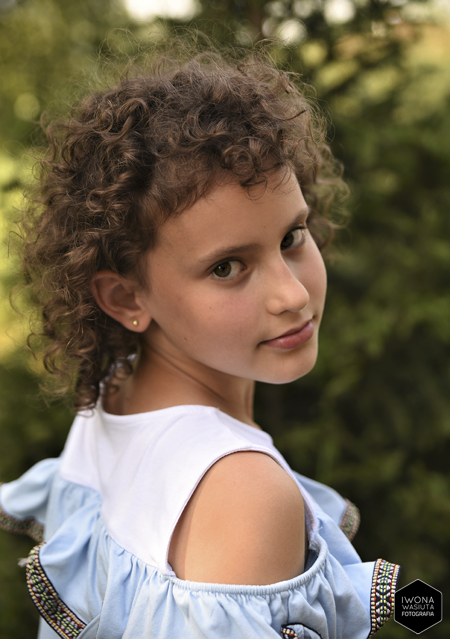 Naturalny portret dziewczynki w zielonym plenerze